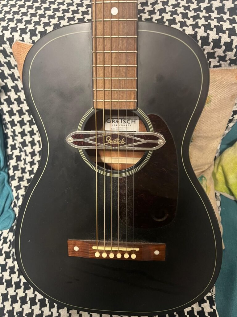 Close-up of a Gretsch Jim Dandy guitar on a patterned surface