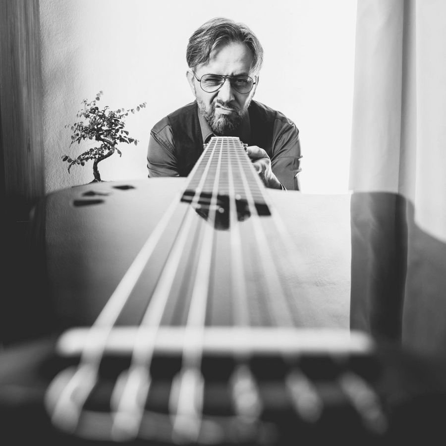 Guitarist studying the fretboard — black and white portrait